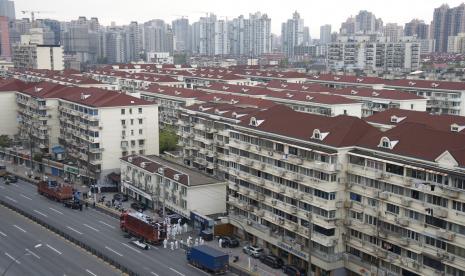 Para pekerja dengan APD menurunkan bahan makanan dari sebuah truk sebelum mendistribusikannya kepada penduduk setempat di bawah penguncian COVID-19 di Shanghai, China Selasa, 05 April 2022. Wabah COVID-19 di kota metropolitan terbesar di China Shanghai tetap 