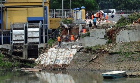 Para pekerja menata batu kali saat memperbaiki tanggul waduk Setia Budi, Jakarta Pusat, Ahad (26/1). (