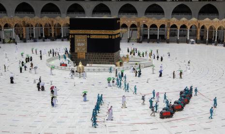 Empat Regulasi Baru Soal Umroh dan Haji Khusus. Para pekerja mendisinfeksi halaman saat para jamaah haji menjaga jarak sosial saat mereka mengelilingi Ka