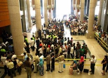 Para pekerja migran tengah mengurus perizinan di kantor imigrasi Malaysia.