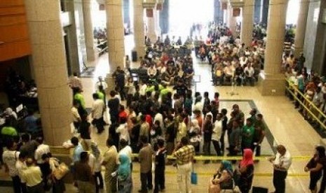 Para pekerja migran tengah mengurus perizinan di kantor imigrasi Malaysia.