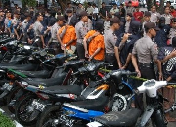 Para pelaku kriminal dijaga oleh Polisi saat ekpose tindak kriminal tahun 2011 di Mapolres Bogor, Cibinong, Jabar.