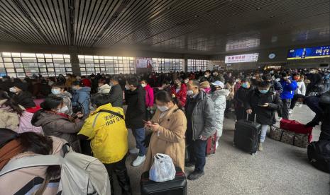 Para pelancong yang memakai masker wajah dengan barang bawaan mereka bersiap untuk mengejar kereta mereka di Stasiun Kereta Api Barat di Beijing, Jumat, 6 Januari 2023. China berupaya meminimalkan kemungkinan wabah COVID-19 baru yang besar selama perjalanan Tahun Baru Imlek bulan ini terburu-buru setelah berakhirnya sebagian besar tindakan penahanan pandemi.