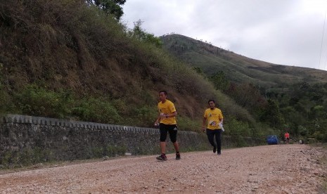 Para pelari Samosir Lake Toba Ultra Marathon sedang melintasi kawasan wisata Danau Toba, Sumatera Utara. 