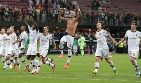 Para pemain AC Milan merayakan kesuksesan mereka lolos ke fase grup Liga Champions.