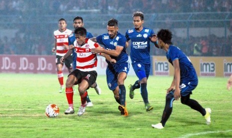 Para pemain Arema Cronus (biru) saat meladeni Madura United.