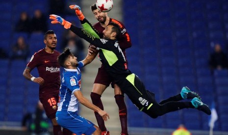 Para pemain Barcelona, yakni Jose Paulo Bezerra atau Paulinho (kiri) dan Gerard Pique (kanan-belakang), serta kiper Espanyol Diego Lopez (kanan-depan) dan pemain Espanyol Mario Hermoso (kedua dari kiri). 