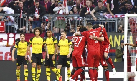 Para pemain Bayern Muenchen merayakan gol pembuka laga Bundesliga melawan Borussia Dortmund di Allianz Arena, Sabtu (6/4). Muenchen menang telak 5-0.