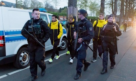 Para pemain Borussia Dortmund mendapatkan pengawalan dari kepolisian Jerman setelah ledakan bom merusak bus yang mereka tumpangi menjelang laga Liga Champions.