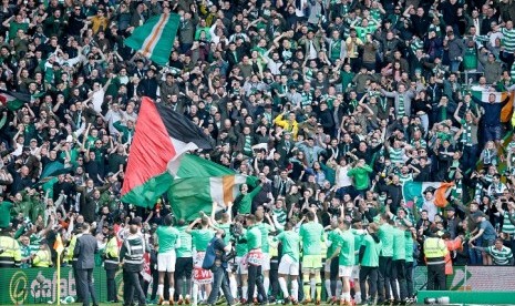 Para pemain Celtic merayakan gelar juara Liga Skotlandia bersama fan mereka di Celtic Park, Ahad (29/4).