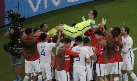 Para pemain Cile melemparkan Claudio Bravo ke atas setelah menjadi pahlawan kemenangan Cile atas Portugal pada semifinal Piala Konfederasi 2017.