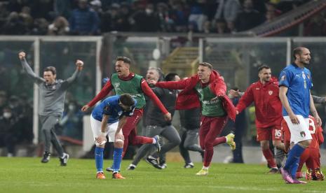 Para pemain Makedonia Utara merayakan saat para pemain Italia bereaksi setelah tim mereka tersingkir di akhir pertandingan play-off kualifikasi Piala Dunia antara Italia dan Makedonia Utara, di stadion Renzo Barbera, di Palermo, Italia, Kamis, 24 Maret 2022. Makedonia Utara menang 1-0.