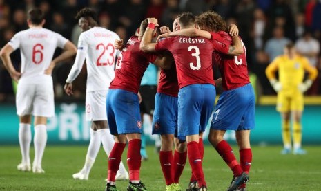 Para pemain Republik Ceska (merah) merayakan kemenangan atas Inggris pada laga kualifikasi Euro 2020. Sementara para pemain Inggris berjalan gontai usai menelan kekalahan pertama.