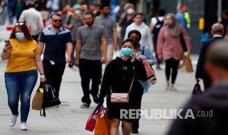 Para pembeli berjalan di sepanjang Oxford Street di London, Selasa, 14 Juli 2020. Pemerintah Inggris menuntut orang-orang mengenakan masker di toko-toko karena mereka berusaha untuk mengklarifikasi pesannya setelah berminggu-minggu pengingkaran di tengah pandemi COVID-19. 