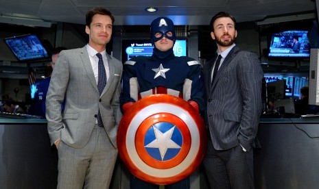 Para pemeran Captain America, Sebastian Stan (kiri) dan Chris Evans (kanan) berpose dengan pria berkostum Kapten Amerika.