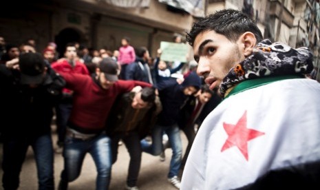 Para pemrotes menari dan meneriakkan slogan-slogan anti-Assad di Kota Aleppo, Suriah.