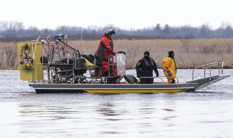 Para pencari mencari korban di Akwesasne, Quebec, Jumat, 31 Maret 2023. Pihak berwenang di Wilayah Mohawk Akwesasne mengatakan, Jumat, satu anak hilang setelah jenazah enam migran keturunan India dan Rumania ditarik dari sungai yang mengangkangi Kanada- perbatasan AS.