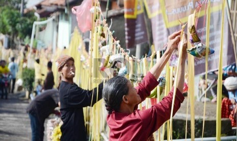  Para penduduk memasang sawen berupa makanan ringan dan hasil pertanian pada acara 'Ngaruat Bumi dan Rempug Tarung Adu Tomat ' di kampung Cikareumbi, Kabupaten Bandung Barat, Kamis (14/11). (Republika/Edi Yusuf)