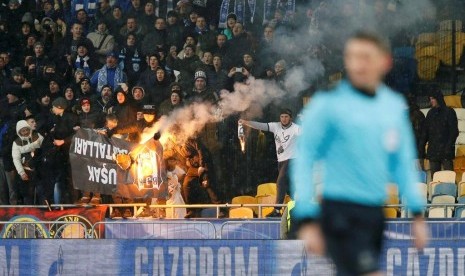 Para pendukung Dynamo Kiev membakar spanduk Besiktas di Stadion Olympiyskiy saat kedua tim berhadapan pada Rabu (7/12) dini hari WIB.