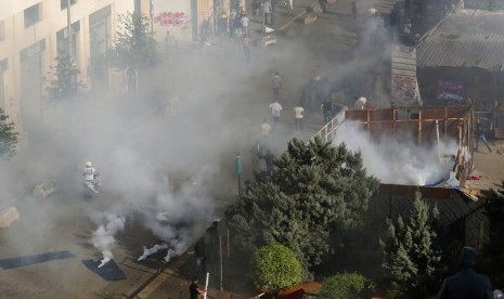 Para pendukung Hizbullah berlari usai polisi menembakkan gas air mata di dekat kantor pemerintahan di Beirut, Lebanon, Selasa (29/10).