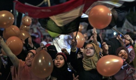 Para pendukung Mursi memegang balon dan mengibarkan bendera saat merayakan Idul Fitri di Kairo 