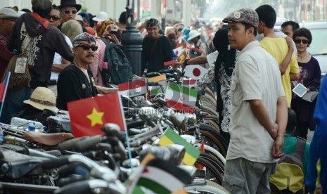 Para penggemar sepeda tua dengan memakai bendera-bendera peserta KAA memarkir sepedanya di Jl Asia Afrika, Kota Bandung, Ahad (19/4). (Edi Yusuf/Republika)