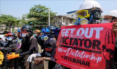 Para pengunjuk berhadapan dengan pasukan anti huru hara selama protes anti-kudeta di Yangon, Myanmar pada 9 Maret 2021.