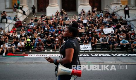  Para pengunjuk rasa berkumpul di sebuah perkemahan di luar City Hall, Selasa, 30 Juni 2020, di New York. Anggota parlemen Kota New York mengadakan debat besar tentang anggaran kota karena aktivis menuntut pergeseran $ 1 miliar dari kepolisian ke layanan sosial dan kota bergulat dengan kerugian jutaan dolar karena pandemi coronavirus.