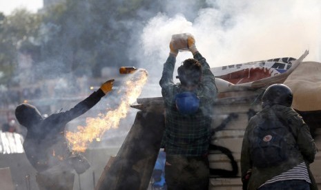  Para pengunjuk rasa melemparkan bom molotov dan kembang api untuk dilemparkan ke arah polisi anti huru hara di Istanbul Taksim Square,Turki, Selasa (11/6).    (Reuters/Murad Sezer)