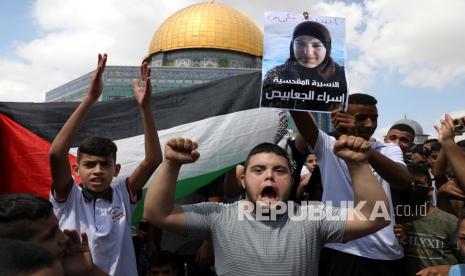 Polisi Israel Interogasi Imam Masjid Al Aqsa. Foto:  Para pengunjuk rasa memegang bendera Palestina dan plakat tahanan Israa Jaabis, yang menderita luka bakar parah dan berjuang untuk perawatan medis, selama protes untuk mendukung tahanan Palestina dan enam yang melarikan diri minggu ini, setelah shalat Jumat di Dome of the Rock Masjid di kompleks Masjid Al Aqsa di Kota Tua Yerusalem,  Jumat (10/9).