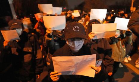  Para pengunjuk rasa memegang kertas kosong dan meneriakkan slogan-slogan saat mereka berbaris sebagai protes di Beijing, Ahad, 27 November 2022. Para pengunjuk rasa yang marah dengan langkah-langkah anti-virus yang ketat menyerukan agar pemimpin kuat China itu mengundurkan diri, teguran yang belum pernah terjadi sebelumnya sebagai otoritas di setidaknya delapan kota berjuang untuk menekan demonstrasi hari Minggu yang mewakili tantangan langsung yang jarang terjadi pada Partai Komunis yang berkuasa.