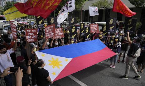  Para pengunjuk rasa memegang slogan-slogan selama rapat umum di depan Konsulat China di kota Makati, Filipina, pada 12 Juli 2021. Kapal penjaga pantai China memblokir dan menggunakan meriam air pada dua kapal pasokan Filipina menuju ke kawanan yang disengketakan yang diduduki oleh marinir Filipina di Laut China Selatan