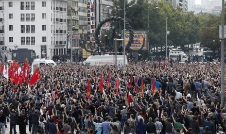 Para pengunjuk rasa mengangkat kepalnya sebagai bentuk penghormatan terhadap korban meninggal dalam pengeboman di Ankara, Turki, Ahad (11/10).