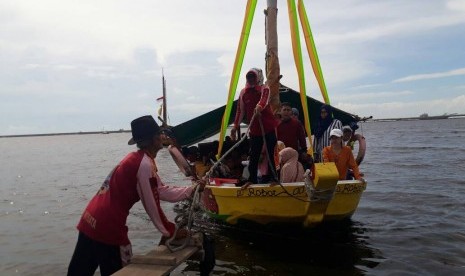 Para pengunjung Pantai Ancol menikmati wahana perahu yang mengelilingi pantai di utara Jakarta, Senin (26/6).