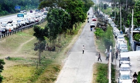 Para penunjuk jalur alternatif Puncak tengah mengarahkan para pengendara keluar dari jalur utama