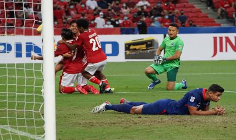 Para pesepak bola Timnas Indonesia (kiri) melakukan selebrasi usai menjebol gawang Timnas Singapura yang dijaga Zulqarnaen Suzliman (kanan) dalam pertandingan Semi Final Leg 2 Piala AFF 2020 di National Stadium, Singapura, Sabtu (25/12/2021).