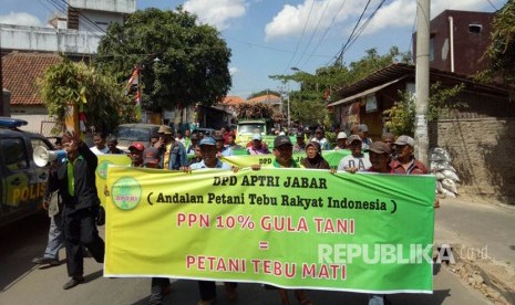 Para petani tebu yang tergabung dalam Andalan Petani Tebu Rakyat Indonesia (APTRI) Jabar menggelar aksi dengan menghadang truk pengangkut tebu dan membagikan gula kepada warga secara gratis di depan pintu masuk Pabrik Gula Sindanglaut, Kecamatan Lemahabang, Kabupaten Cirebon, Kamis (24/8).