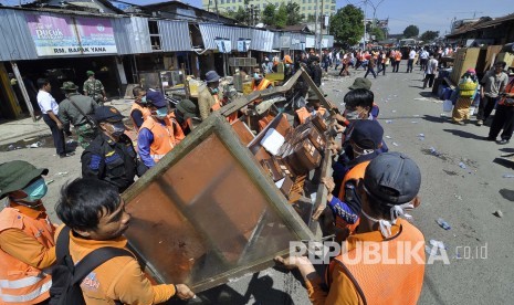 Para petugas membatu mengeluarkan barang-barak pada eksekusi lahan, PT Kereta Api Indonesia (KAI), Jl Stasiun Barat, Kota Bandung, Selasa (26/7). (Mahmud Muhyidin)