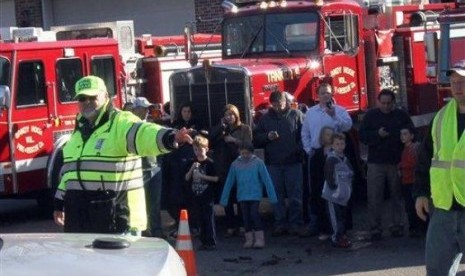 Para petugas tengah mengevakuasi siswa-siswa di the Sandy Hook Elementary School setelah aksi penembakan brutal di sana, di Connecticut, AS, Jumat (14/12) waktu setempat. 