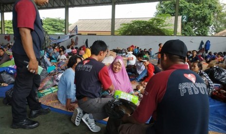 Para relawan Artha Graha Peduli (AGP) memberikan bantuan berupa keperluan bayi kepada seorang ibu di lapangan tenis Kalianda yang merupakan lokasi pengungsian untuk warga Pulau Sebesi dan Pulau Sebuku, Lampung Selatan, Kamis (27/12).