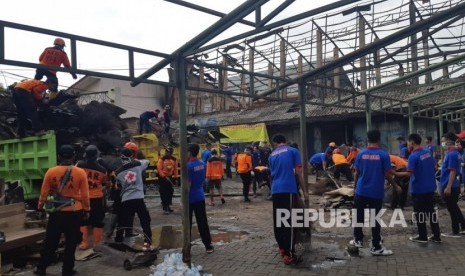 Para relawan bekerja bakti membersihkan Pasar Legi, Solo, Ahad (11/11). Merek membersihkan puing-puing bangunan pasar yang terbakar sekitar dua pekan lalu tersebut.