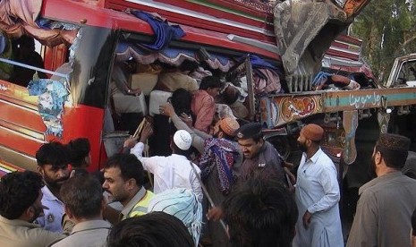 Para relawan dan warga bahu-membahu menyelamatkan penumpang bus yang mengalami kecelakaan di Pakistan.