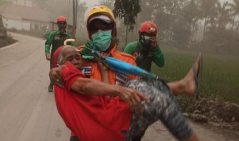 Para relawan melakukan evakuasi terhadap warga Desa Supit Urang, Kecamatan Pronojiwo, Kabupaten Lumajang, Ahad (4/12/2022).