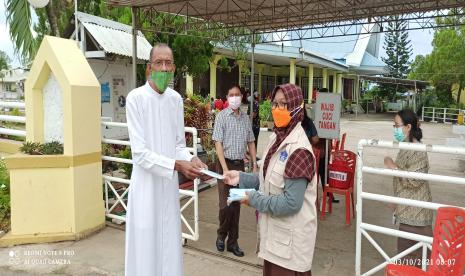 Para relawan memulai aktivitas pada pagi hari untuk membagikan masker kepada warga yang akan beribadah. Mereka berada di gerbang bersama pengelola gereja untuk memastikan jemaatnya dalam kondisi sehat. 