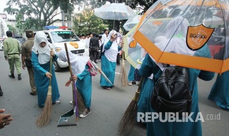 Para santri membersihkan Jalan-jalan di kawasan Alun-alun pada peringatan Hari Santri Nasional 2017 Tingkat Jawa Barat yang dipusatkan di halaman Masjid Raya Provinsi Jawa Barat, Alun-alun Kota Bandung, Kamis (26/10).