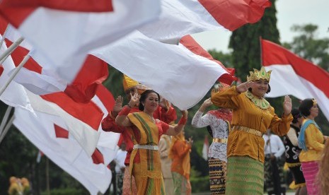 Para seniman menari dengan mengenakan pakaian adat dari berbagai daerah di Indonesia dalam kegiatan doa bersama Nusantara Bersatu di lapangan Margarana, Denpasar, Rabu (30/11).