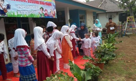 Para siswa TK Bina Insani Bogor menyerahkan bingkisan kepada anak-anak yatim.