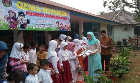 Kepala TK Bina Insani Femy Balti dan Manajer Islamic Studies Sekolah Bosowa Bina Insani Bogor M Sudrajat  menyerahkan santunan kepada siswa SD dari kalangan yatim di Sekolah TK Bina Insani Bogor, Jawa Barat, Jumat 