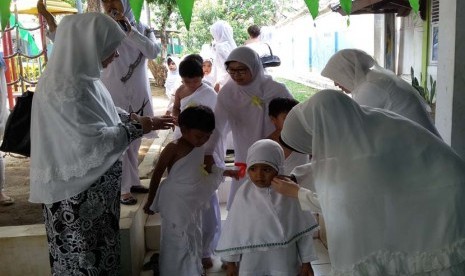 Para siswa TK Bina Insani melaksanakan tahalul (memotong sebagian rambut) pada peragaan manasik haji yang digelar di TK Bina Insani Bogor, Jawa Barat, Jumat (16/10).