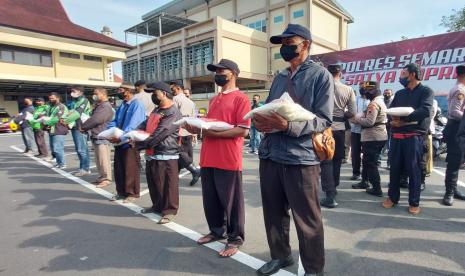 Para sopir angkutan umum, awak truk, driver ojek online (ojol), ojek pangkalan (opang), tukang parkir, kuli panggul pasar dan lainnya menerima bansos berupa sembako yang disalurkan Polres Semarang, di Ungaran, kabupaten Semarang, Jumat (9/9). Bantuan ini dislurkan untuk membantu kelompok masyarakat terdampak kenaikan harga BBM sekaligus sebagai untuk mengendalikan inflasi.